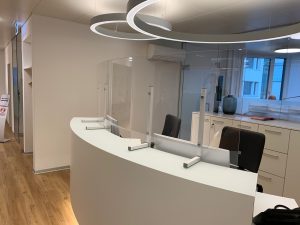 Hygiene-Schutzscheibe gebogen an Empfangsschalter, Fixierung mit pulverbeschichteten MODULUS-Konsolen